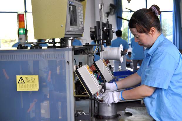 皖南电机员工在操作自动嵌线设备 皖南电机员工在操作自动嵌线设备